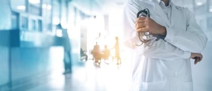 Ein Arzt mit einem Stetoskop steht in einem Klinikflur